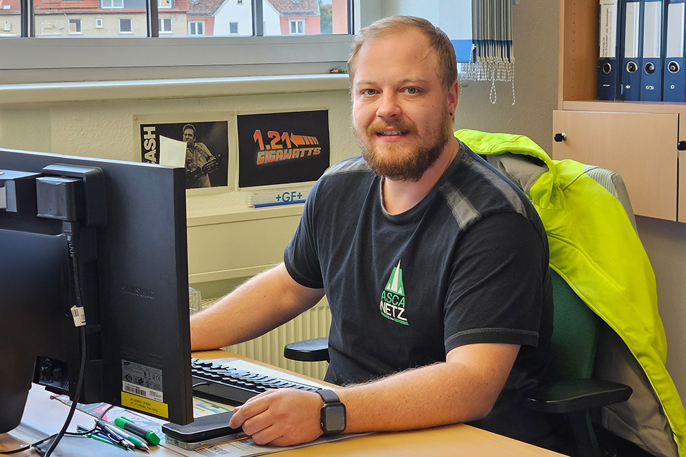 Mitarbeiter Florian Freigang sitzt am Computer